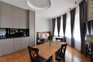 a kitchen and dining room with a wooden table and chairs at Karlo Main Square Apartments in Zagreb