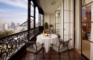 a dining room table with a balcony overlooking a city at Fairmont San Francisco in San Francisco