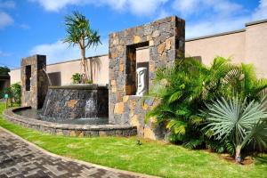 a stone fountain in front of a building at Villa Athena at Grand Baie with private pool in Grand Baie