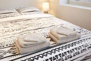 een slaapkamer met een bed met handdoeken erop bij LocationsTourcoing- Le Valmy in Tourcoing