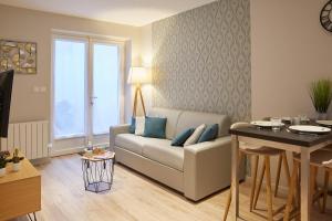 un soggiorno con divano e tavolo di LocationsTourcoing- Le Valmy a Tourcoing
