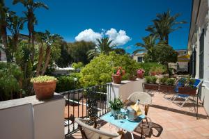 uma varanda com mesa, cadeiras e plantas em Hotel Floridiana Terme em Ischia