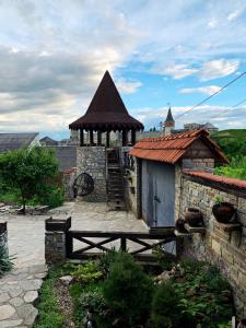 a building with a gazebo and a wooden fence at Nazar Stodolya in Kamianets-Podilskyi