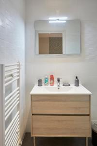 bagno con lavandino e specchio di LocationsTourcoing- Le Valmy a Tourcoing