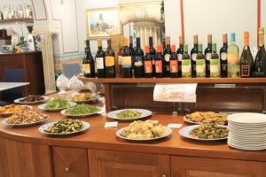 a buffet with plates of food and bottles of wine at Hotel Medusa in Lampedusa