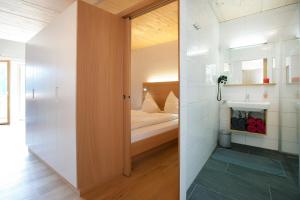 Baño pequeño con cama y lavabo en Appartementhaus Uga, en Damüls