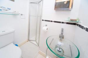 y baño con ducha, lavabo y aseo. en Cosy Snug with shower ensuite - It has beautiful countryside views - Only 3 miles from Lyme Regis, Charmouth and River Cottage - It has a private balcony and a real open fireplace - Comes with free private parking, en Axminster