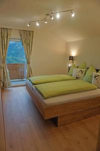 a bedroom with a large green bed with a window at Ferienwohnung Wipptalblick in Navis