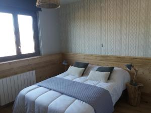 ein Schlafzimmer mit einem großen Bett mit weißer Bettwäsche in der Unterkunft Chalet du Toit Vosgien in Gérardmer