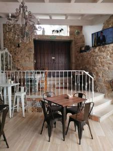 una mesa y sillas en una habitación con una pared de piedra en CARBALLO DE PRADO 1900 en Pontevedra