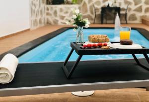 a tray of food on a table next to a swimming pool at Canaryislandshost l Nazaret Suites in Nazaret