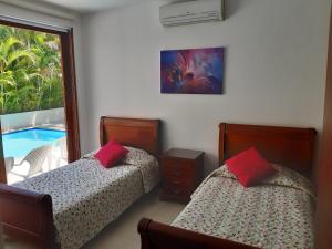a bedroom with two beds and a swimming pool at Lagos del Peñon: Casa 10 - Puerto Madero in Girardot +31 photos