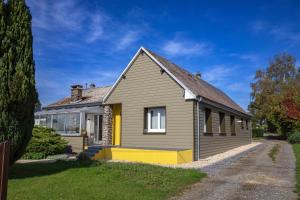 une maison à la façade jaune et gris dans l'établissement Paisible Maison entière 140m2 avec véranda vue sur la campagne, à Renwez