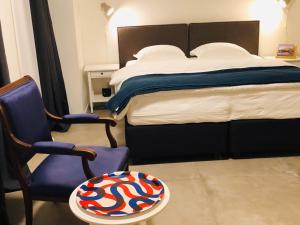 a bedroom with a bed and a chair and a table at B&B Mondriaan in Amsterdam