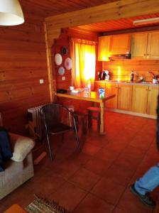 a living room with a table and a kitchen at Chalet 52, Serra da Estrela a perder de vista in Penhas da Saúde