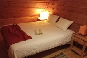 a bedroom with a bed with shoes on it at Chalet 52, Serra da Estrela a perder de vista in Penhas da Saúde