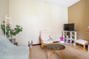 a living room with a couch and a table and a tv at Chez Charlotte in Angres