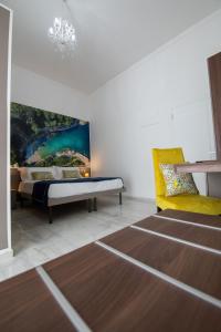een slaapkamer met een bed en een gele stoel bij Palazzo Caracciolo del Sole in Terzigno