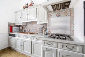 a kitchen with white cabinets and a stove at Chez Charlotte in Angres