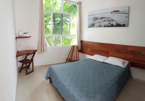 a bedroom with a bed and a window at Gran Jaguar Hotel in Bacalar