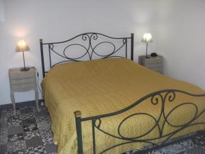 un letto in una camera con due comodini e due lampade di grange dans ancien corps de ferme a Bellengreville