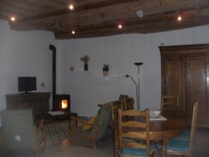 ein Esszimmer mit einem Tisch, Stühlen und einem Kamin in der Unterkunft grange dans ancien corps de ferme in Bellengreville