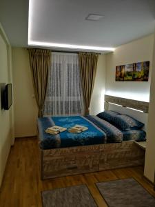 a bedroom with a large blue bed in a room at Apartman Maximus Zlatibor in Zlatibor