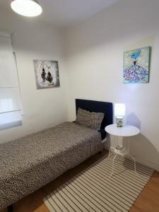 - une chambre avec un lit et une petite table dans l'établissement Casa Coqueta y confortable en Oviedo, à Oviedo