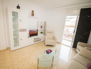 uma sala de estar com um sofá e uma mesa de vidro em Alacant Home: Santa Pola. Piso moderno a 200 metros de la playa em Santa Pola