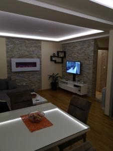 a living room with a table and a tv at Apartman Maximus Zlatibor in Zlatibor