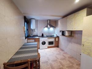 a small kitchen with a table and a microwave at Calle Río Deva 17 in Oviedo