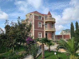 a large red brick building with a tower at Luxury Villa with pool and waterfall in Bina