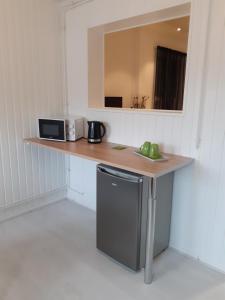 a kitchen with a counter with a microwave and a sink at La belle étoile in Varennes-en-Argonne