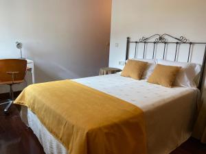 カルダス・デ・レイスにあるCarmenの黄色い毛布が掛けられた大きなベッドのある寝室