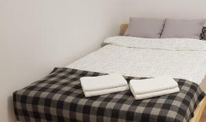 a bed with two pillows on top of it at Rynek Staromiejski Apartment in Koszalin