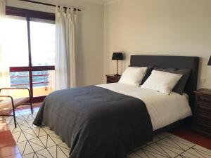 a bedroom with a large bed and a window at Beachfront Apartment with Swimming Pool in Mindelo