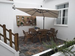 a table and chairs with an umbrella on a patio at Bruma Home in Velas