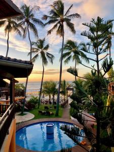 uitzicht vanaf het balkon van een resort met palmbomen bij Pousada Janelas do Mar in Flecheiras
