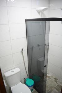 y baño con aseo y ducha acristalada. en Nova Suíte - centro de Domingos Martins + Café da manhã en Domingos Martins