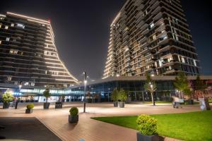 a large building with two tall buildings at night at Belgrade Waterfront GREEN Apartment in Belgrade