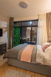 una camera con un letto e una grande finestra di Belgrade Waterfront GREEN Apartment a Belgrado