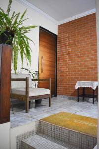 un patio con un banco y una pared de ladrillo en Nova Suíte - centro de Domingos Martins + Café da manhã, en Domingos Martins