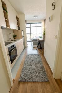 uma cozinha e sala de estar com um tapete no chão em Belgrade Waterfront GREEN Apartment em Belgrado