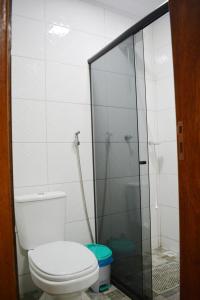 a bathroom with a toilet and a glass shower at Nova Suíte - centro de Domingos Martins + Café da manhã in Domingos Martins