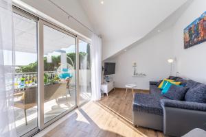 a living room with a couch and a balcony at Matanovi dvori in Milna