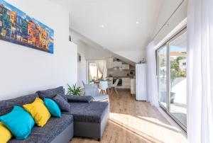 a living room with a gray couch with colorful pillows at Matanovi dvori in Milna