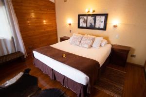 a hotel room with a large bed with pillows at Ngahu Bungalows Alojamiento Frente al Mar en el centro de Rapa Nui in Hanga Roa