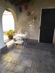 Un patio con sillas y una mesa y una puerta. en la casetta, en Abbadia Lariana