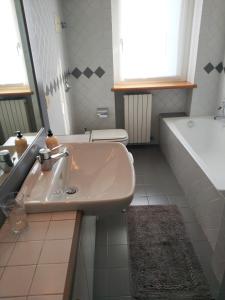 Un baño con lavabo, bañera e inodoro. en la casetta, en Abbadia Lariana 14 fotos más