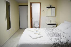 1 dormitorio con cama, lavabo y aseo en Nova Suíte - centro de Domingos Martins + Café da manhã en Domingos Martins